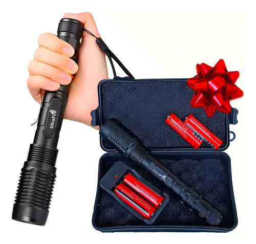 Linterna táctica UltraFire XM-L T7 de 15000 a 20000 lúmenes con estuche rígido, cuatro baterías 18650 y cargador dual de pared. Tiene un moño de regalo en la esquina.